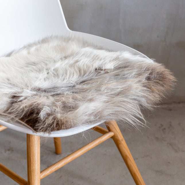 Van Buren chair pad van schapenvacht gemêleerd op de zitting van een witte stoel